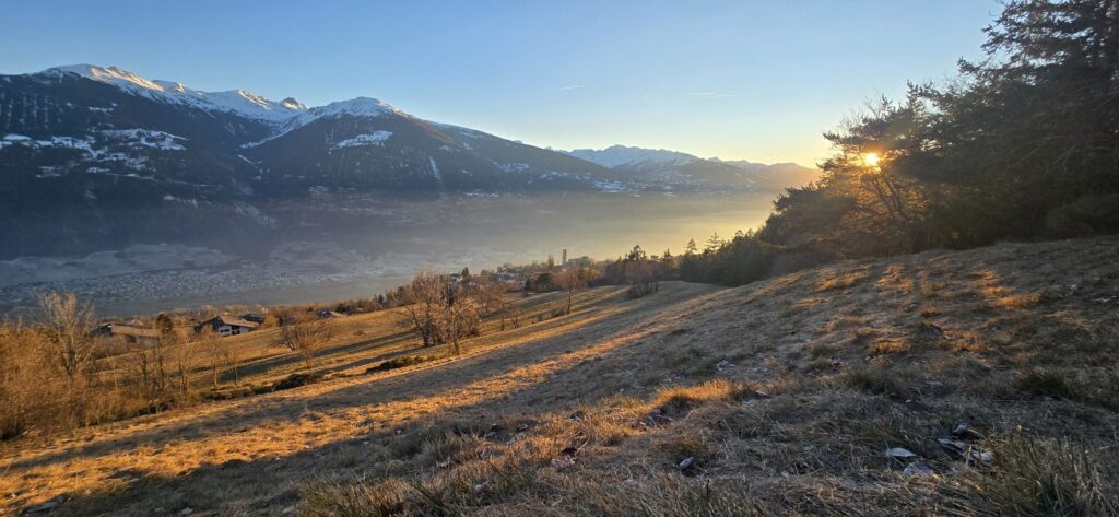 Coucher de soleil Valais avec ombres portées et vue sur la vallée du Rhône.